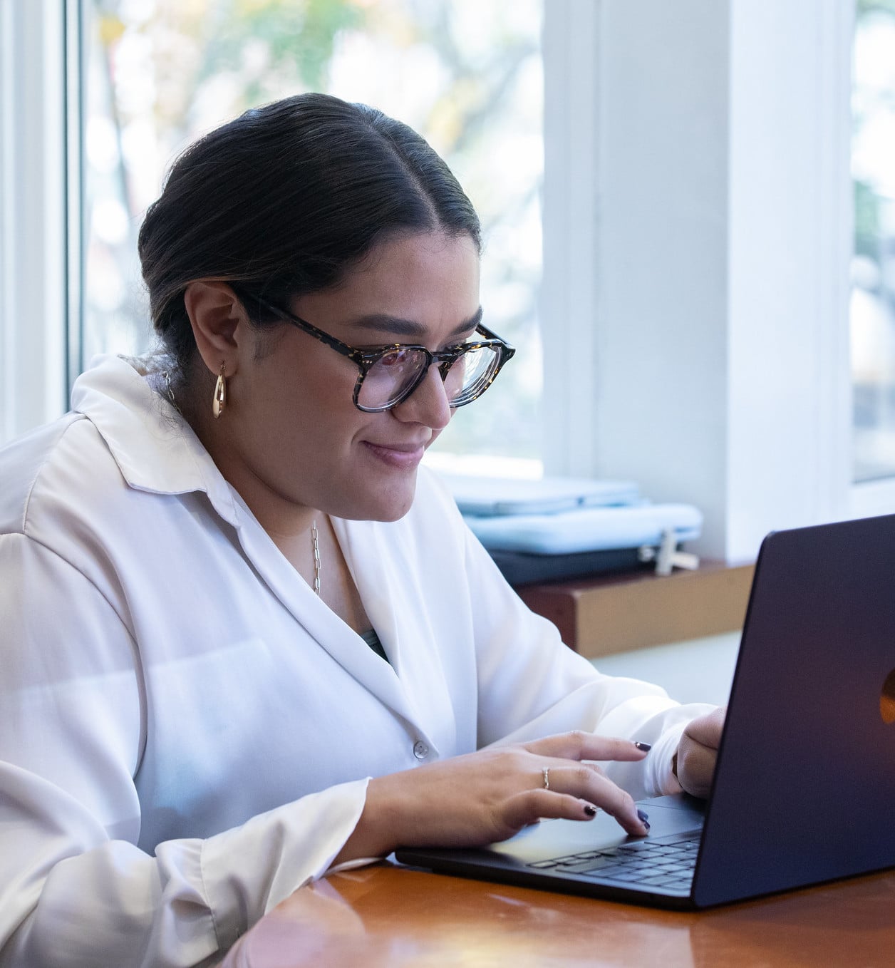 A young professional sits using a laptop to attend a conference.